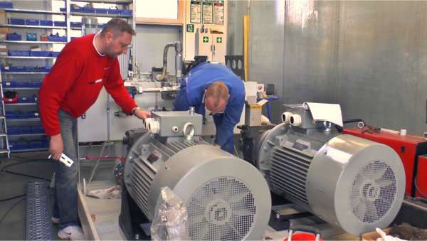 Zwei Mitarbeiter bei der Montage eines Hydraulikaggregats mit zwei Motoren