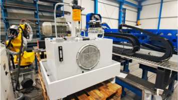 Weißes Hydraulikaggregat mit Motor und Leitungsführung an einer Maschine